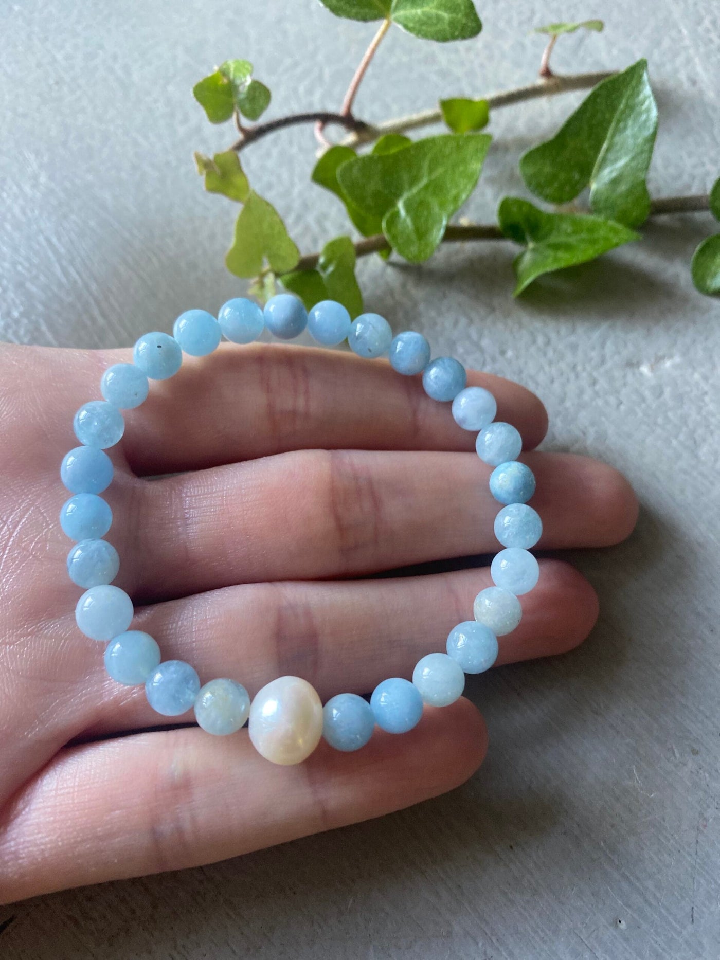 Beaded aquamarine bracelet with freshwater pearl on a hand