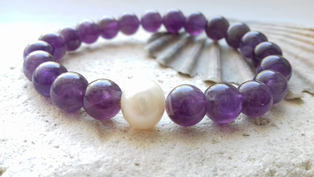 Amethyst bracelet with white freshwater pearl on a pale background