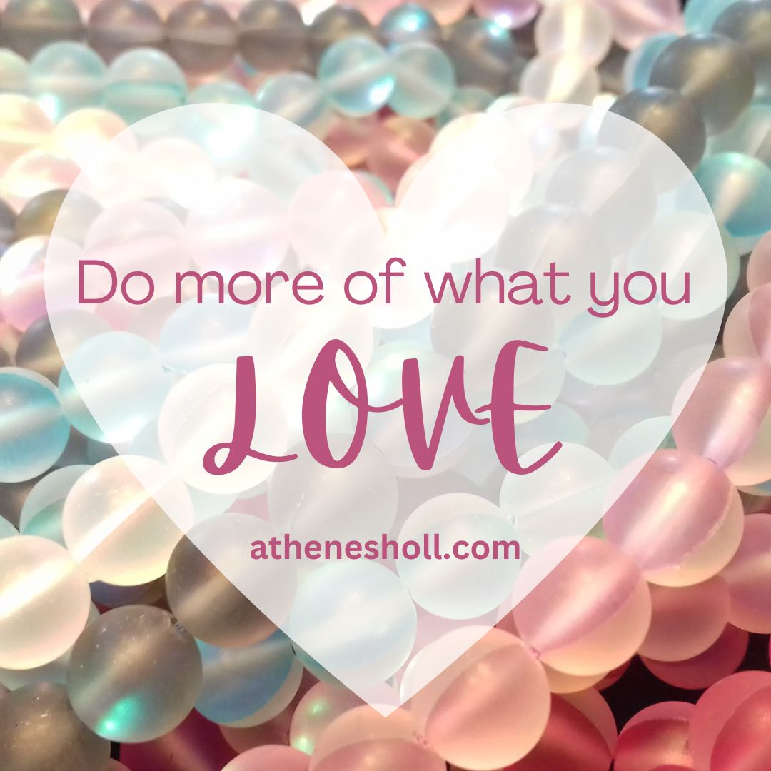 A heart-shaped graphic overlay with the quote 'Do more of what you LOVE' and the website athenesholl.com, set against a background of iridescent pastel beads in pink, blue, and white.