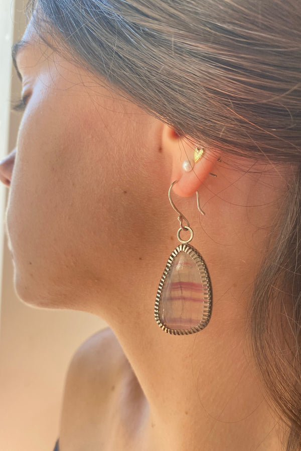 Banded Flourite gemstones in a handmade silver serring worn by a model
