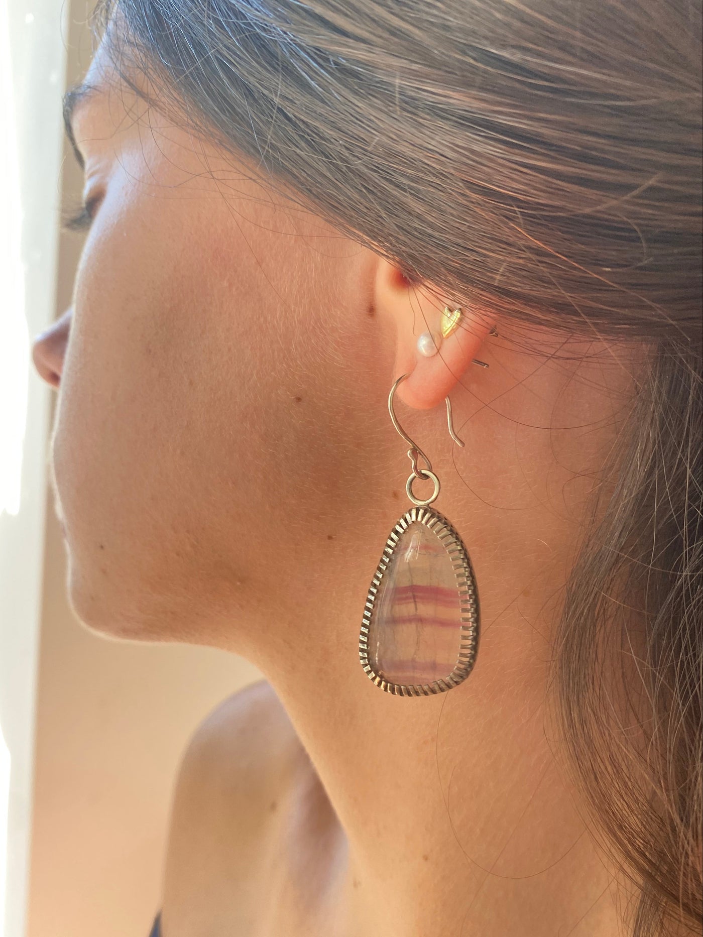 Banded Flourite gemstones in a handmade silver serring worn by a model