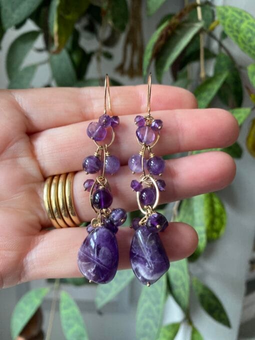 Amethyst waterfall earrings hanging from a hand, yellow gold handmade links