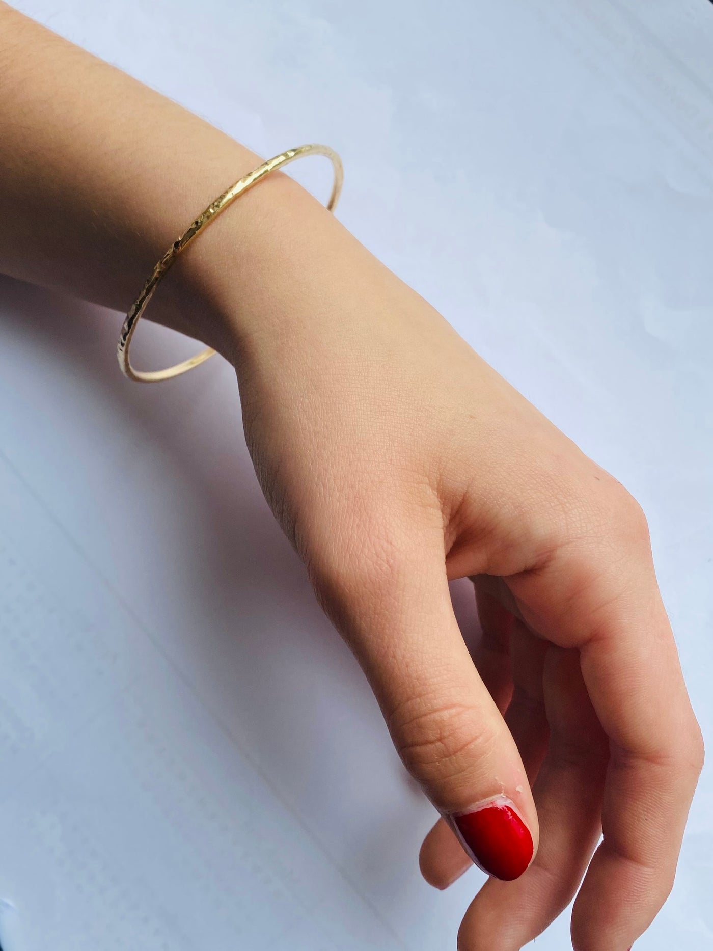 hammered gold bangle worn on a wrist