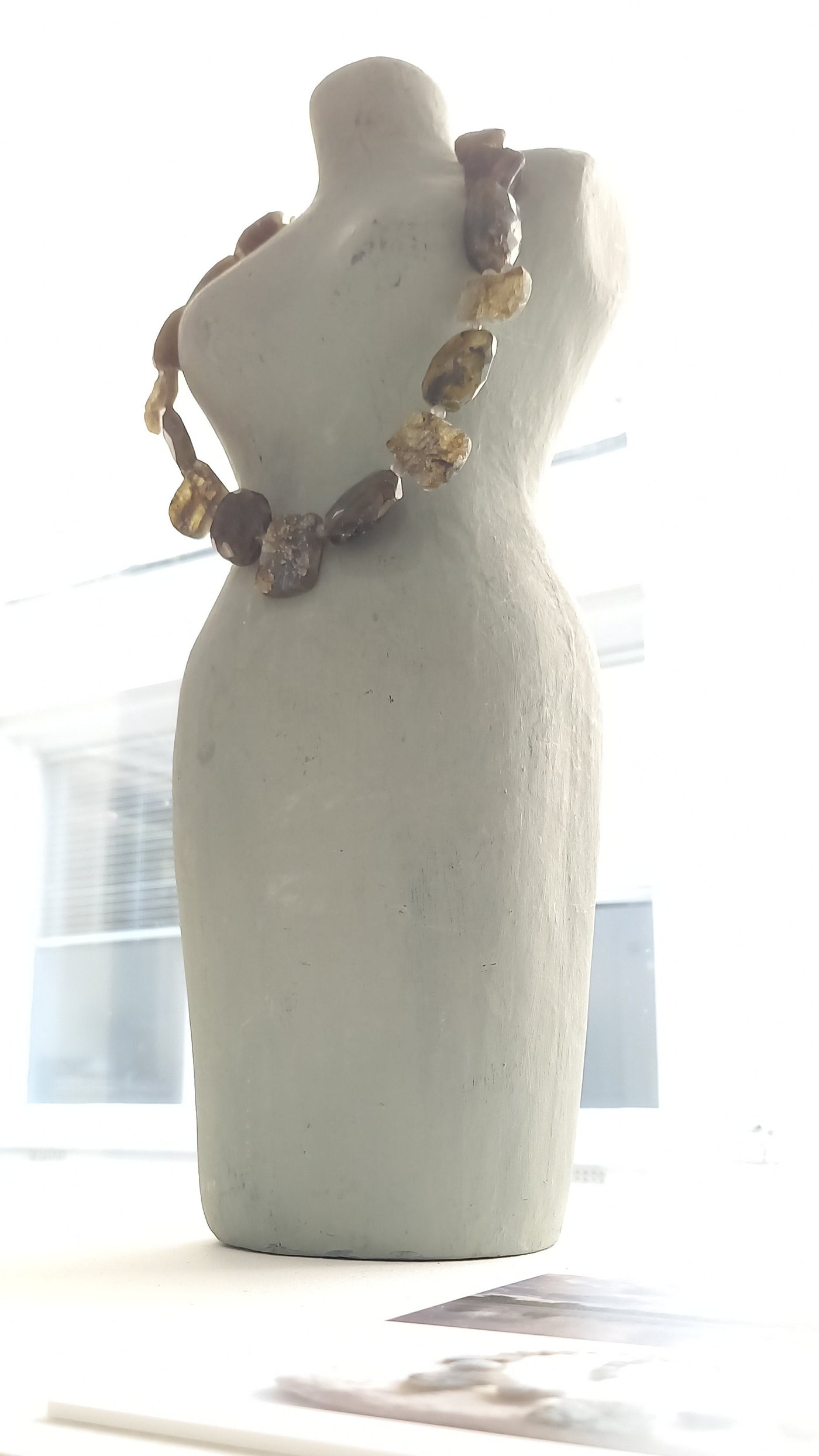 Handmade labradorite necklace on a mannequin bust in the "Art for Guernsey"  gallery against a window with natural light