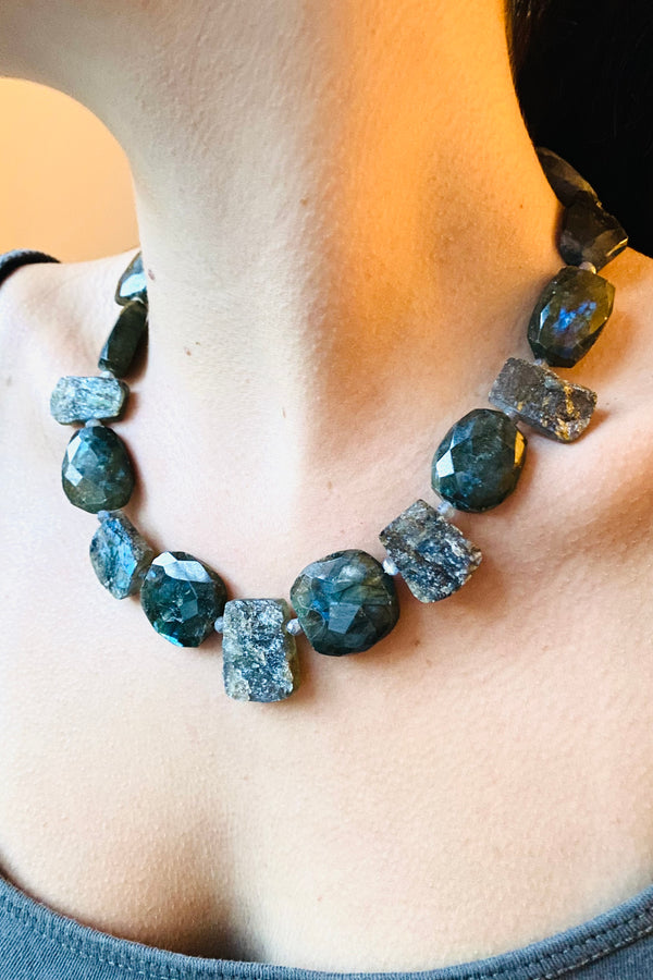 Necklace in labradorite gemstone slabs and faceted beads, worn by a model. 