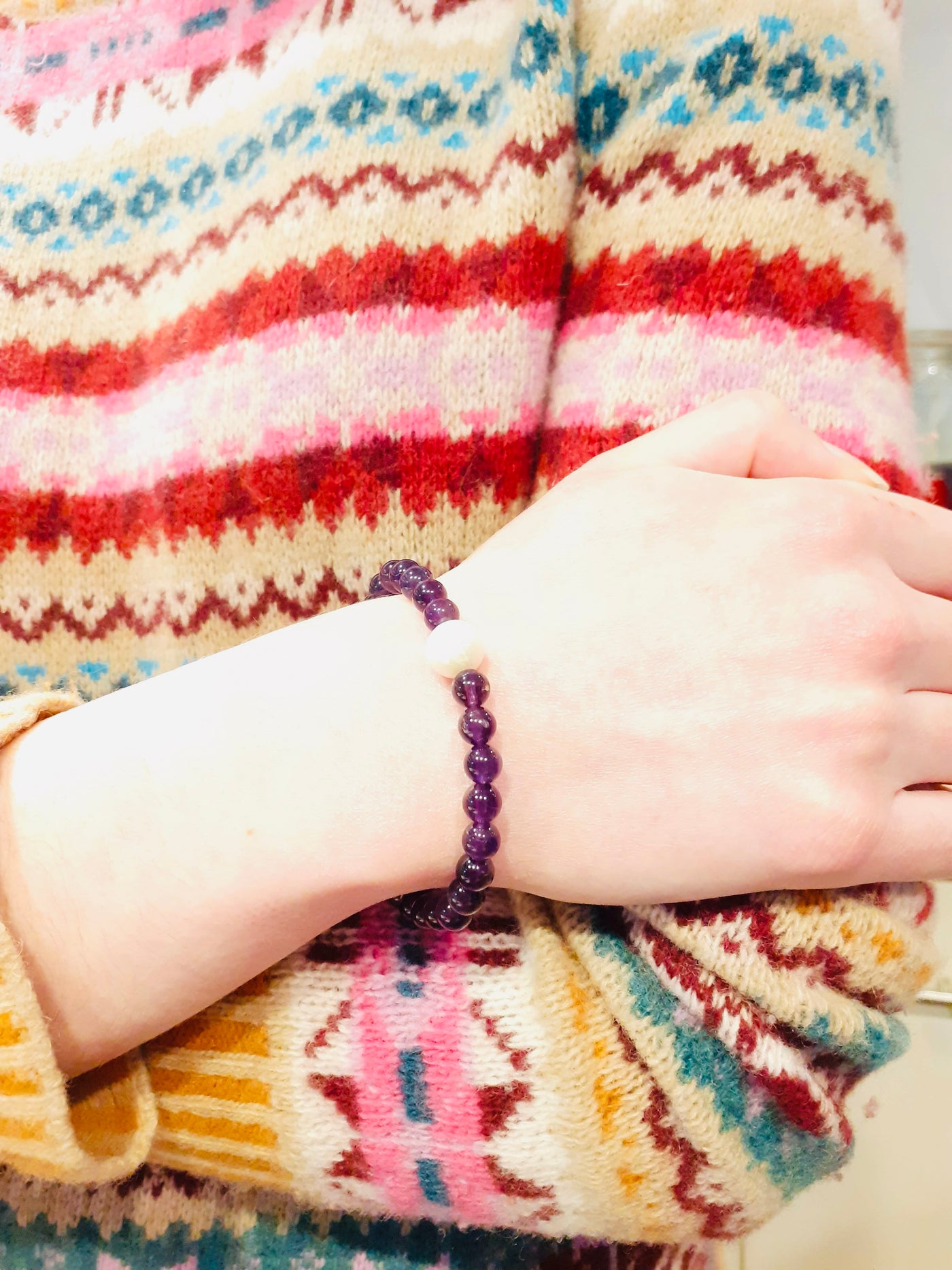 purple amethyst bracelet being worn by a person in a festive stripey jumper