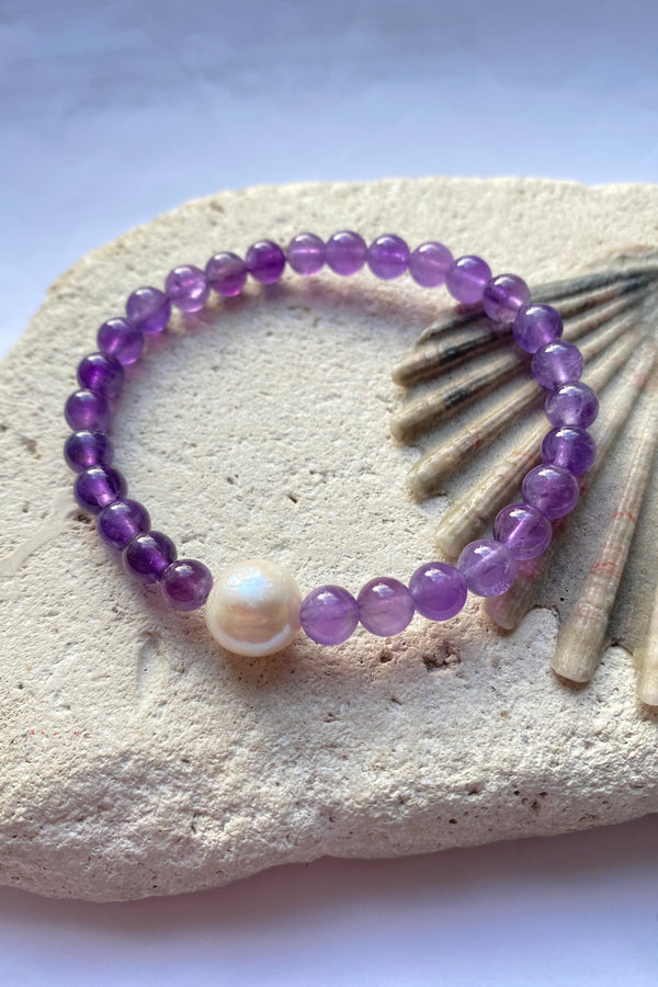 purple amethyst bracelet on a stone background