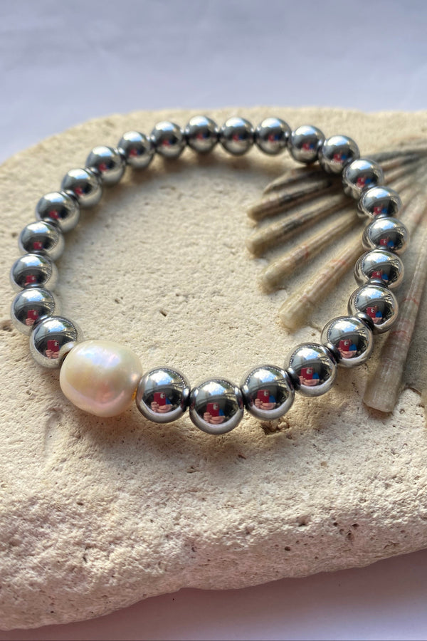 Hematite bead bracelet on a stone background