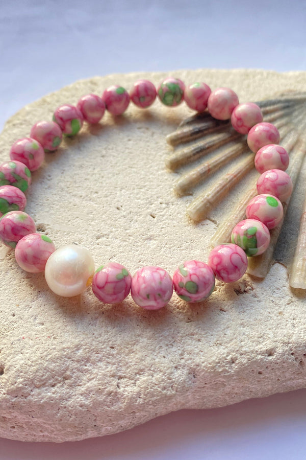 Pink jade bracelet on a stone background