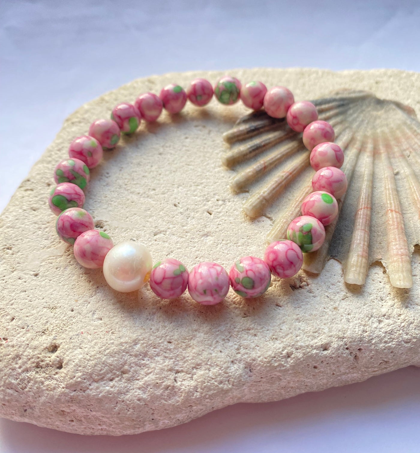 Pink jade bracelet on a stone background