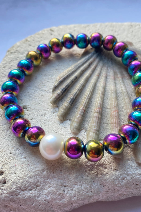 rainbow hematite bead bracelet on a stone background