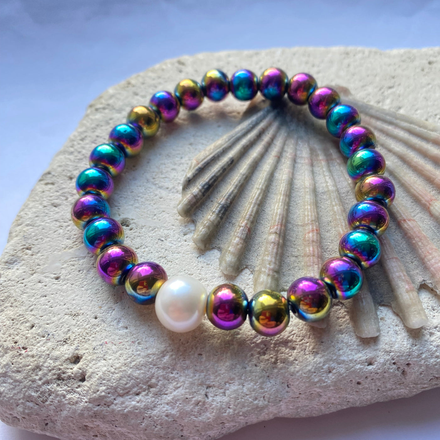 rainbow hematite bead bracelet on a stone background