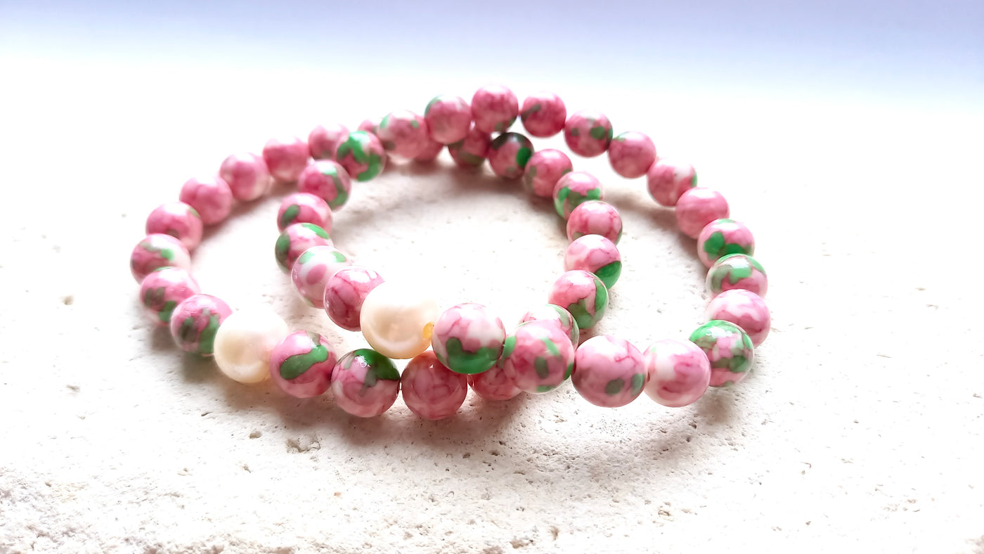 pink jade bracelets stacked on a stone background