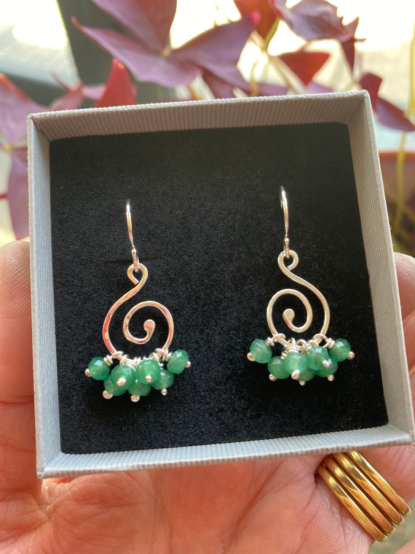 silver and emerald gemstone spiral earrings in a gift box lined with black velour
