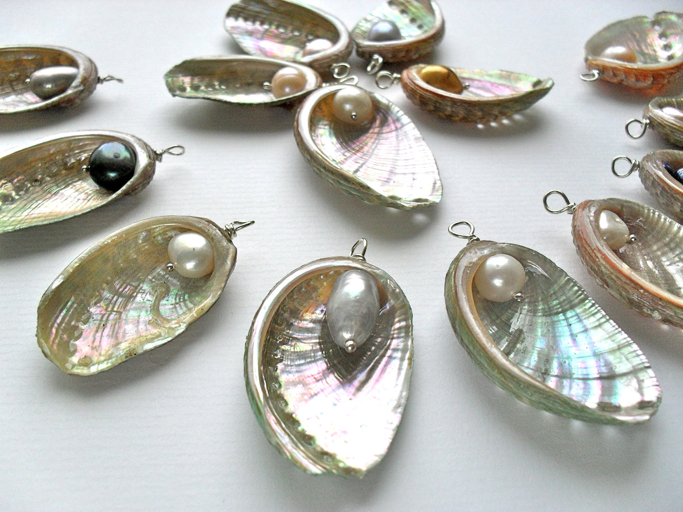 Shell pendants with freshwater pearls on a white background