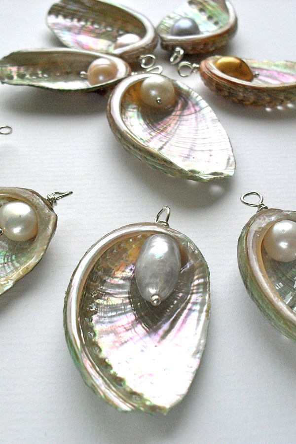 Shell pendants with freshwater pearls on a white background