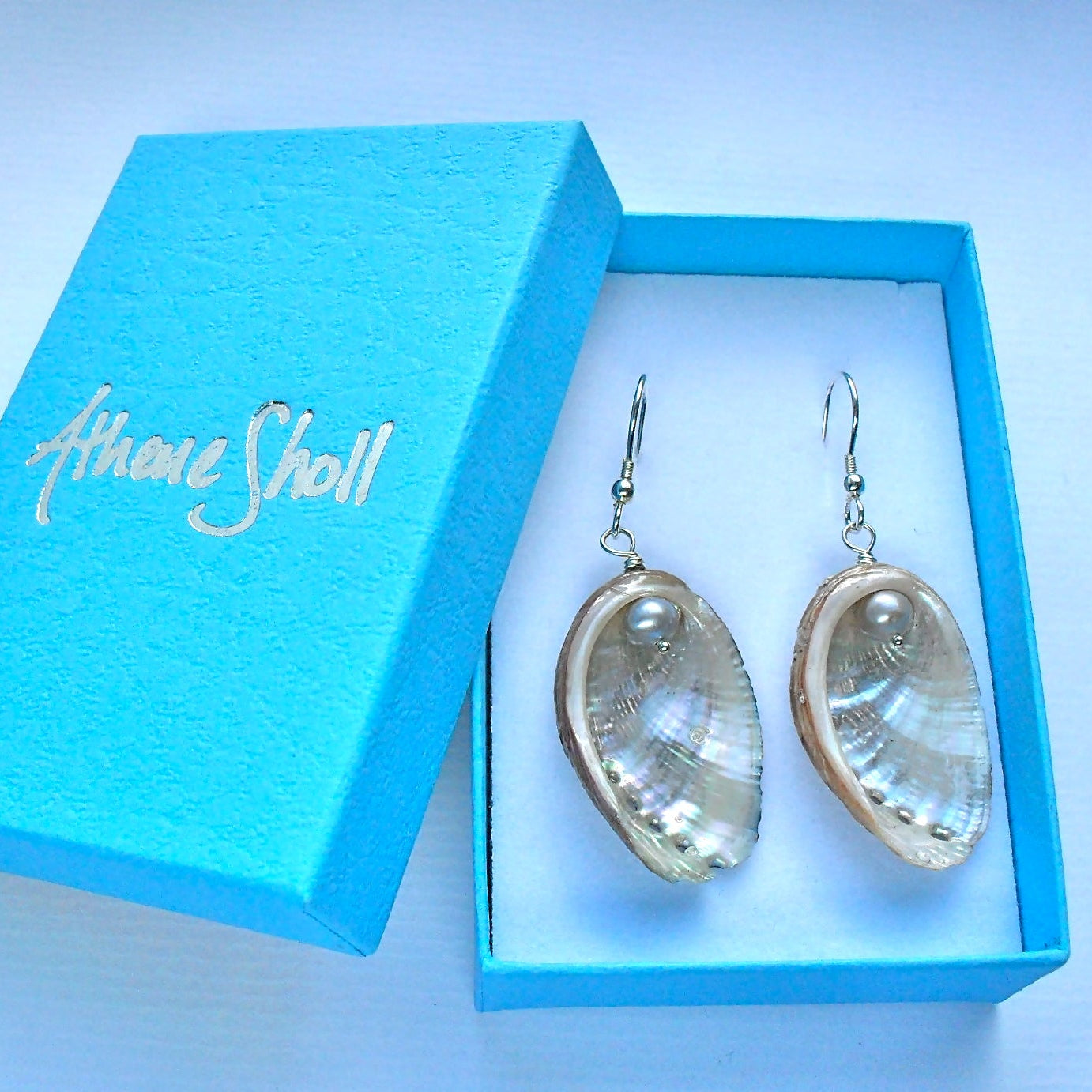 Guernsey natural ormer shell earrings with grey freshwater pearl accents, displayed in a gift box