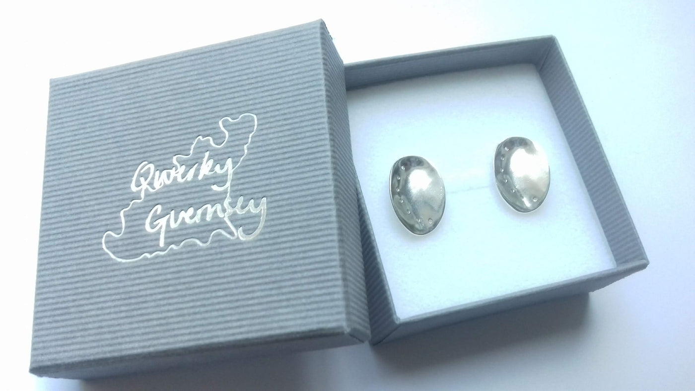 Silver ormer earrings in a 'Qwerky Guernsey' branded box on a white background