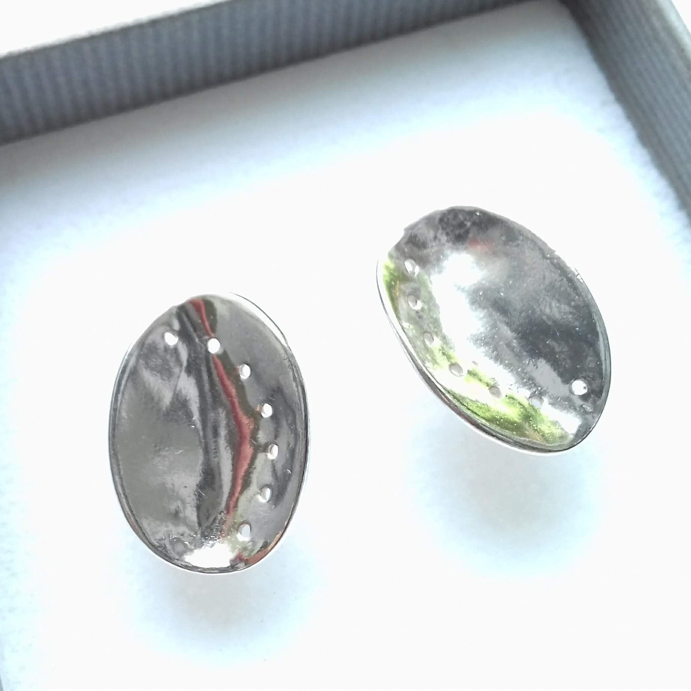Textured silver guernsey ormer earrings in a gift box on a white background