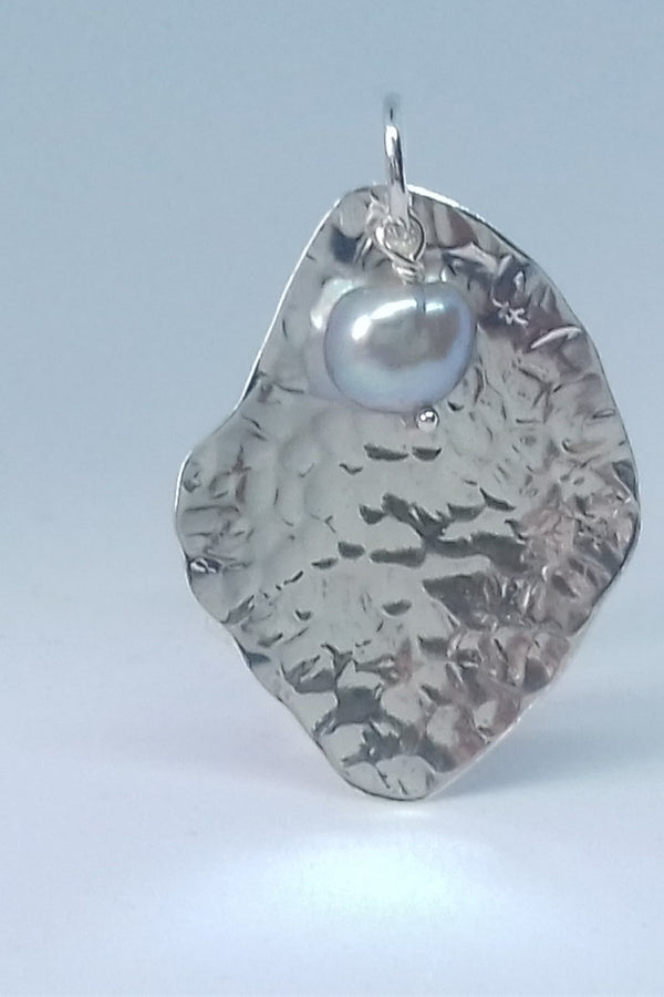 Silver pendant with a textured design on a light gray background