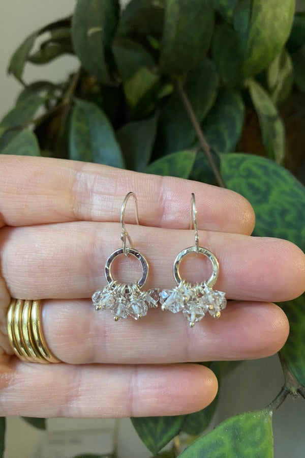 Textured silver earrings with herkimer diamonds suspended in a ruffle