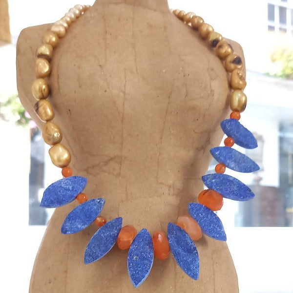 Necklace with marquise shaped blue lapis lazuli gemstones and vibrant orange carnelian faceted gemstone beads on a mannequin in the "Art for Guernsey" gallery. 