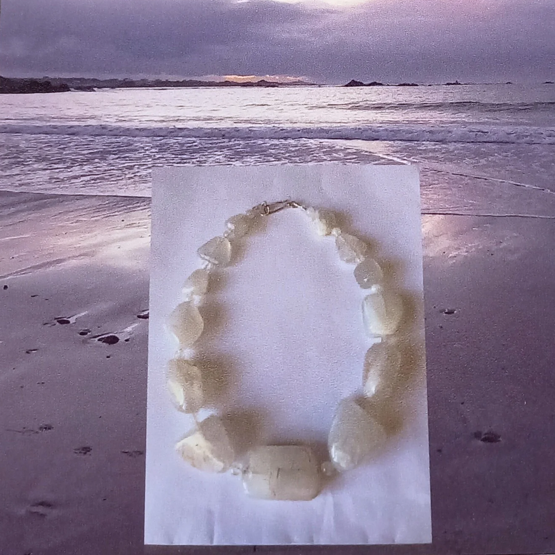 Necklace on the beach scene that inspired it, with ocean and sky in the background