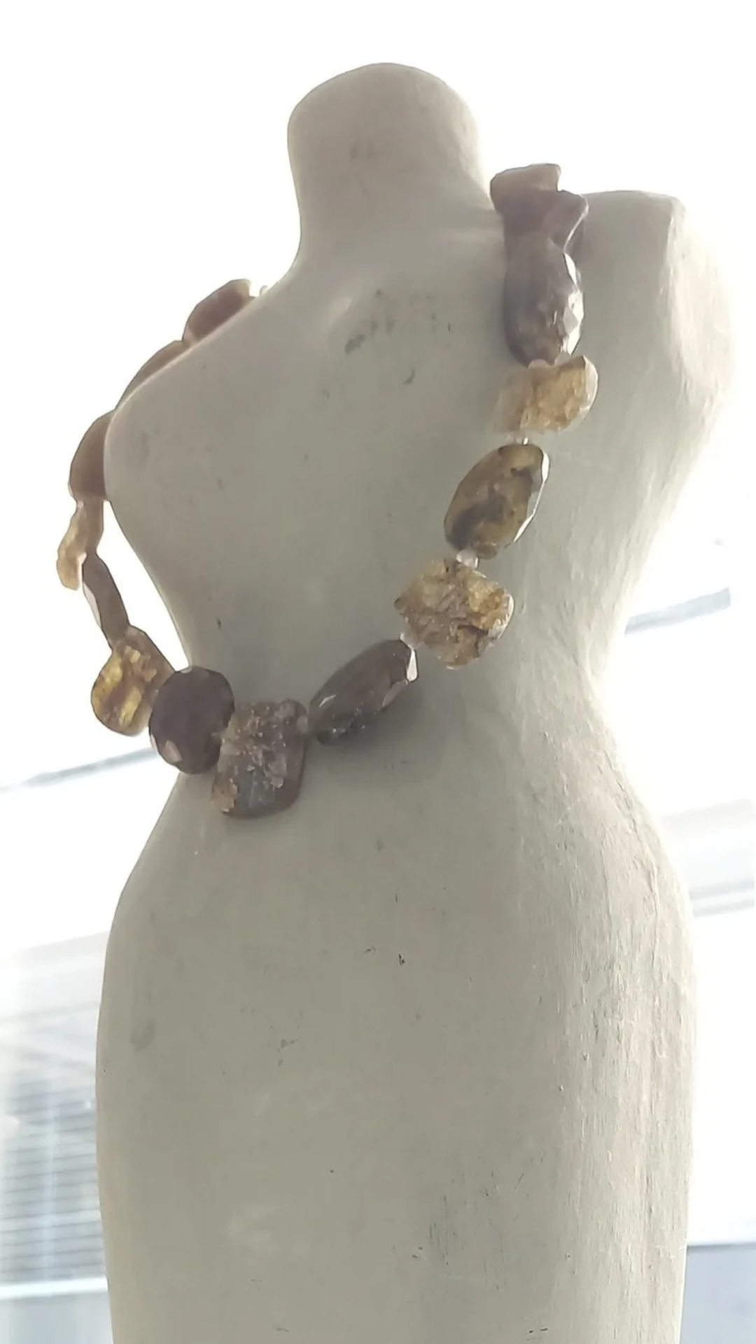 Labradorite gemstone necklace on a mannequin bust in a gallery setting. 