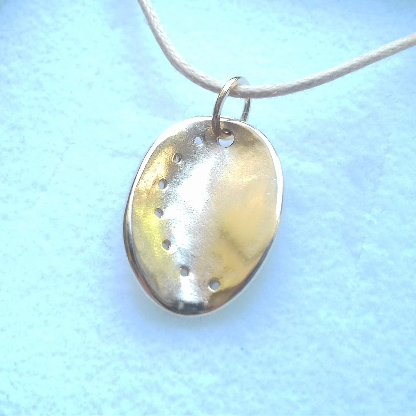 Guernsey ormer shell pendant in 9ct yellow gold on a cotton cord, displaid in a gift box. 