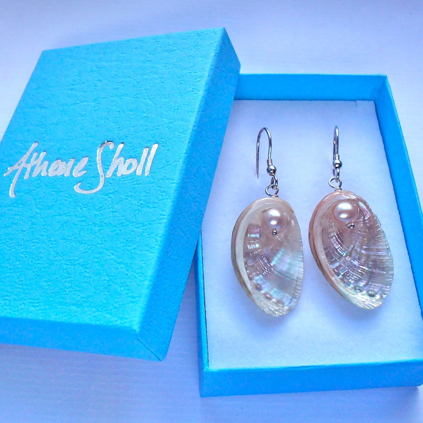 Guernsey natural ormer shell earrings with pink freshwater pearl accents, displayed in a gift box