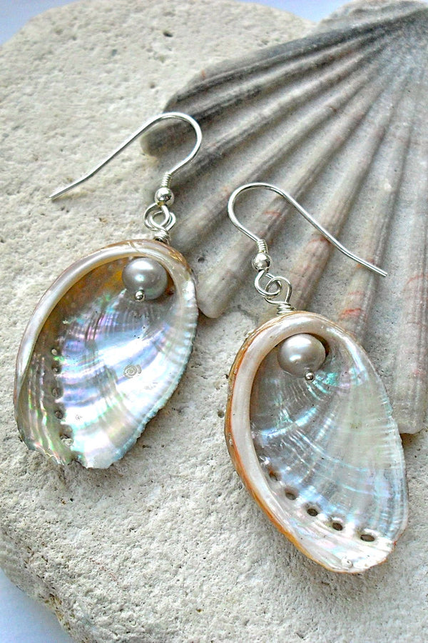 Guernsey Ormer Shell earrings with pearls on a stone surface