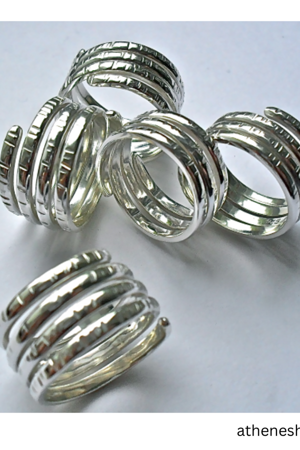 Five silver spiral wrap rings with textured ridges, displayed on a light gray background with a website watermark in the bottom right corner.