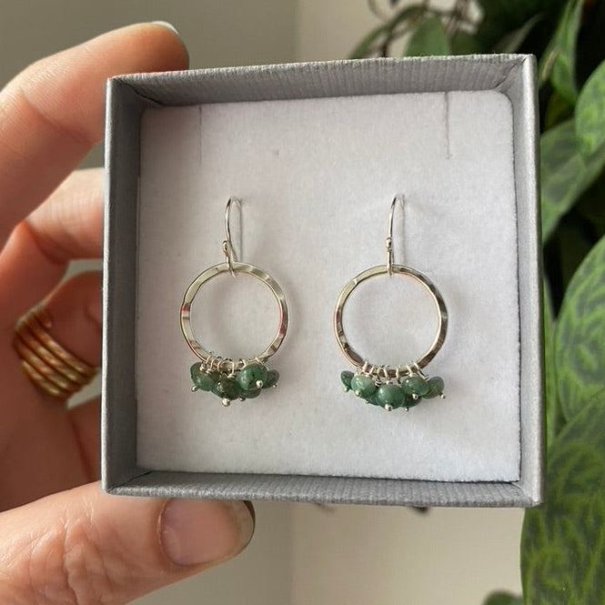 Hammered silver circle earrings with a green emerald gemstone ruffle