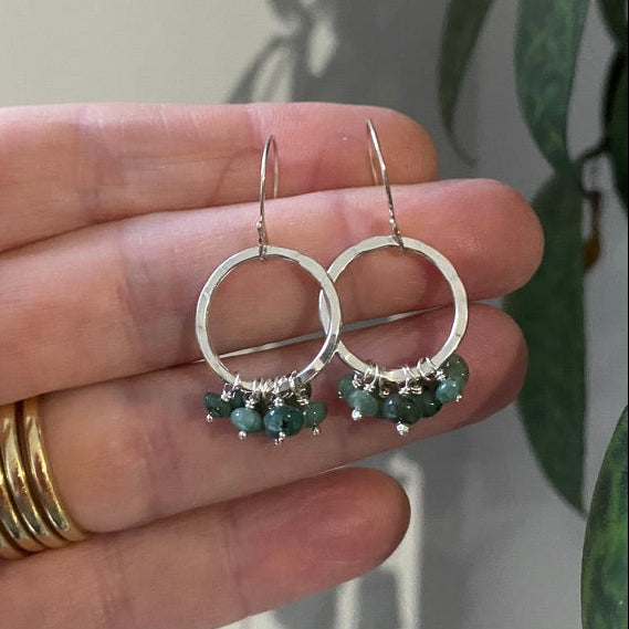 Silver circle earrings in hammered silver with a ruffle of green emerald gemstones
