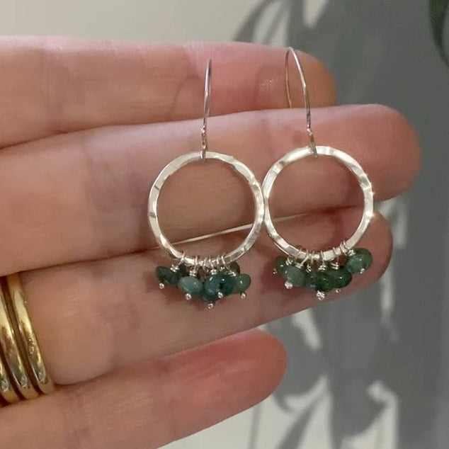 Textured silver circle drop earrings with a green emerald gemstone ruffle