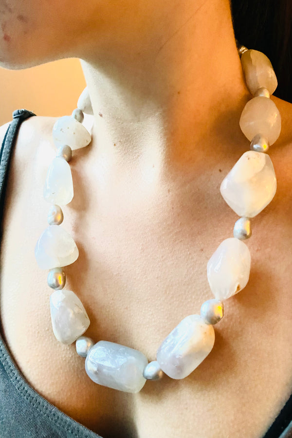 White opal necklace with large white beads and silver grey freshwater pearls worn on a model 