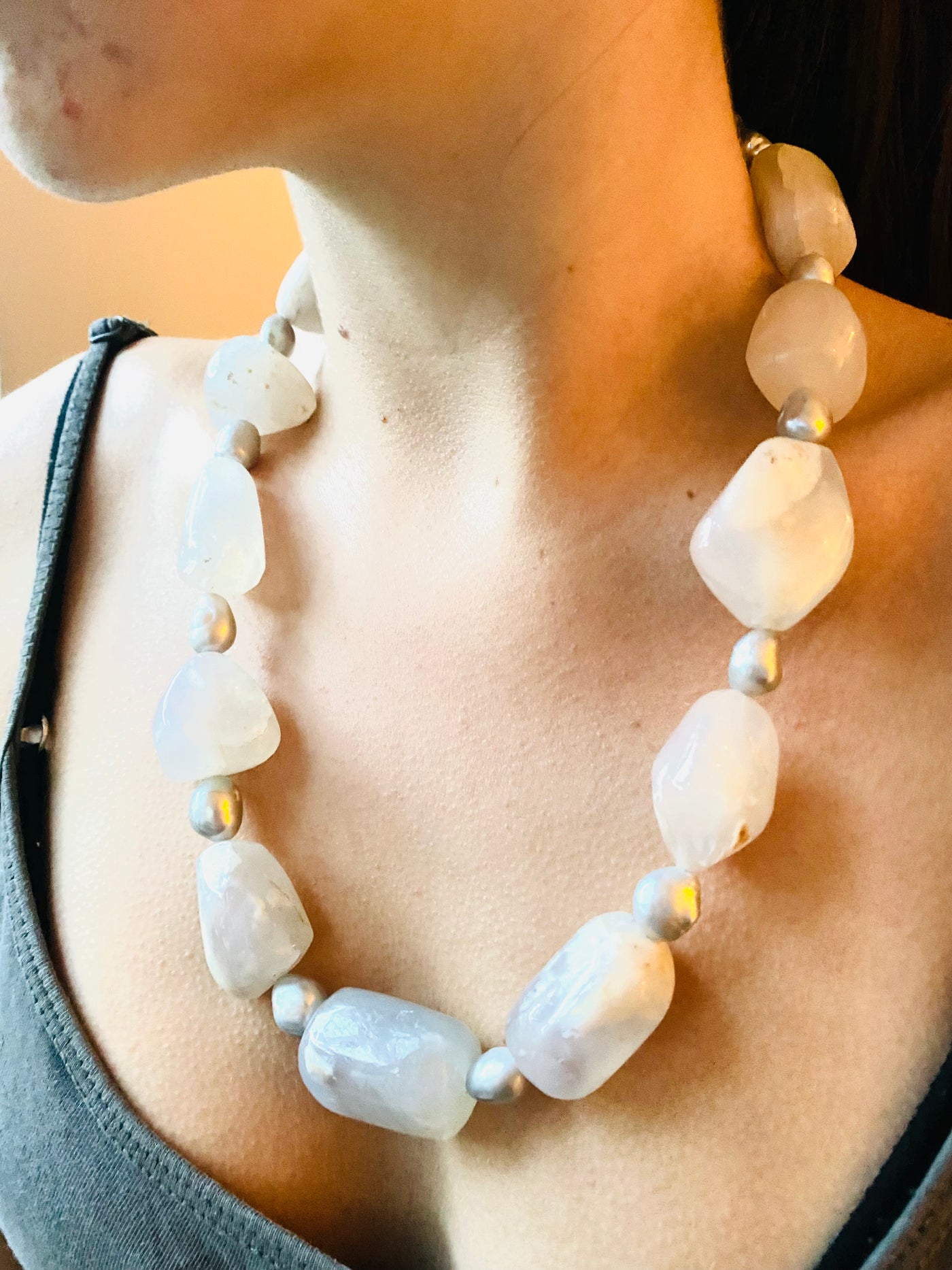 White opal necklace with large white beads and silver grey freshwater pearls worn on a model 