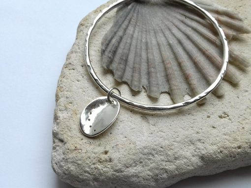 Textured silver bangle with silver ormer shell dangle charm.