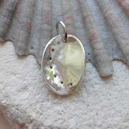 Recycled Silver Ormer Shell Pendant sitting on a rock.
