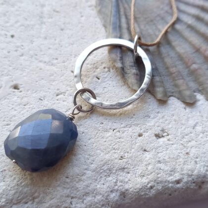 Large faceted sapphire stone with a textured silver circle pendant