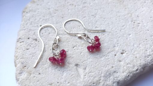 Small Silver Ovals with 3 red faceted rubies hanging form it.