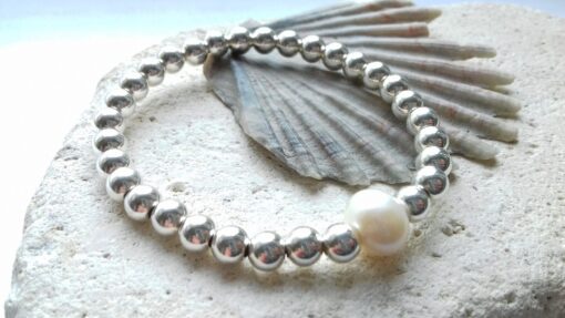 Small sterling silver beaded bracelet with larger off white pear at the centre