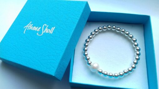 silver beaded bracelet in a blue textured gift box with silver embossed logo