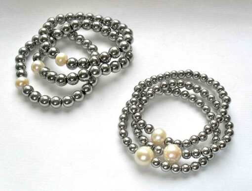 Two stacks of silver hematite beaded bracelets with whit pearl accents