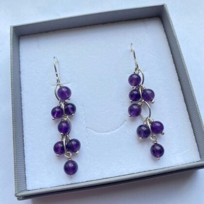 Earrings of amethyst stones suspended from sterling silver links.