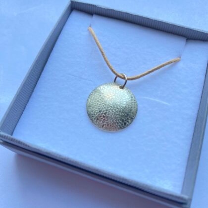 9ct gold circle pendant hand engraved with chrysanthemum design.